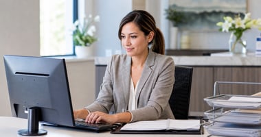 Practice administrator working on a laptop in a healthcare office. 