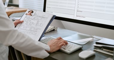 Healthcare professional reviewing patient records and clinical documentation using electronic health record software