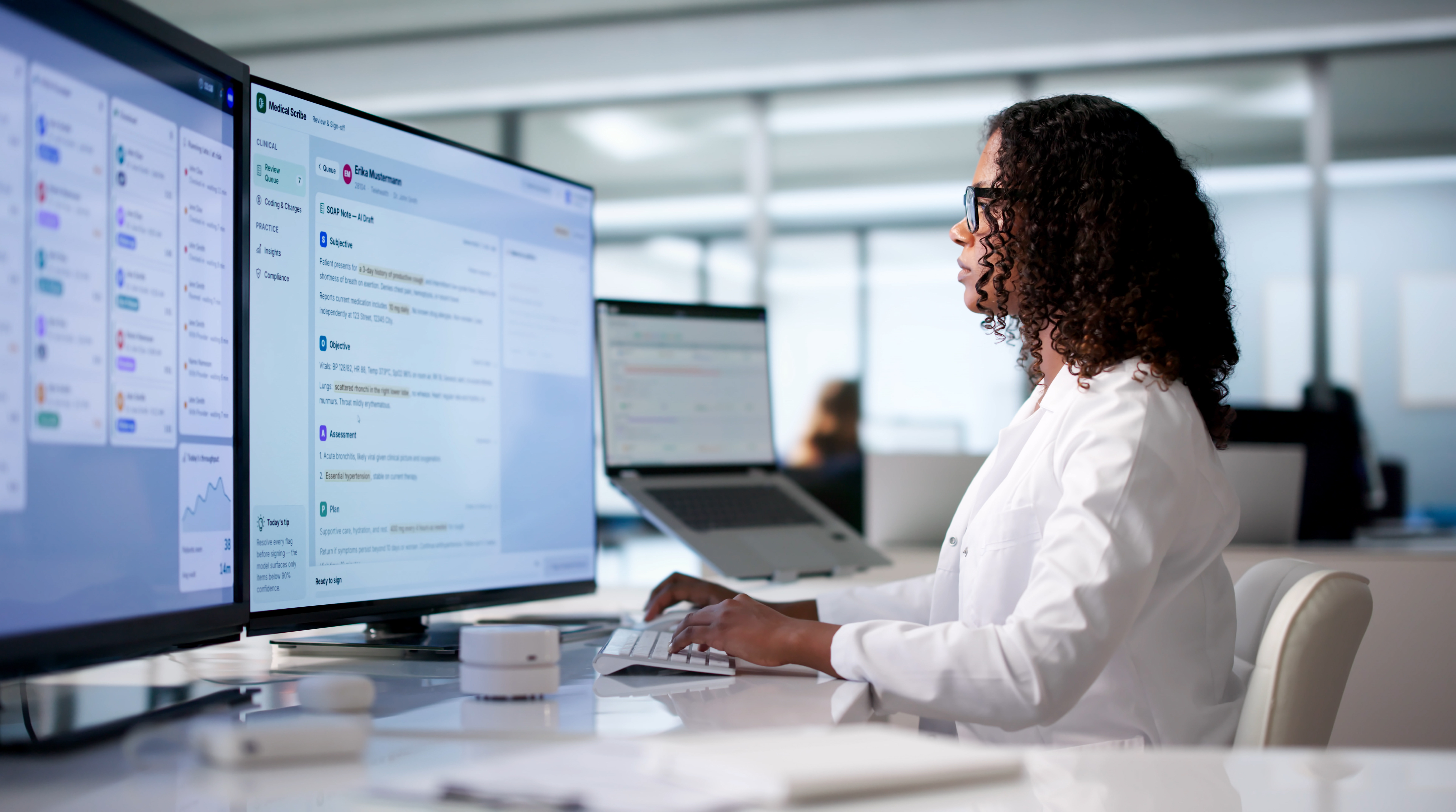 Healthcare professional using clinical documentation and workflow software at a multi-screen workstation